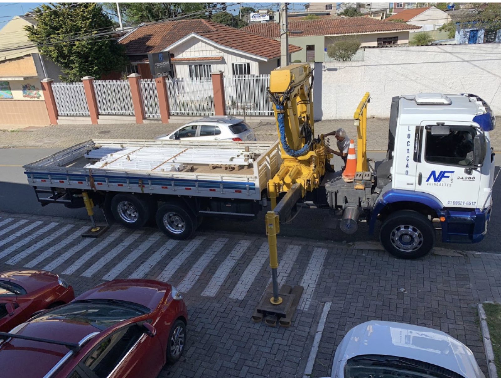 Munck da NF. Guindastes operando carga e descarga em obra em Curitiba